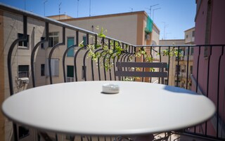 Una mesa redonda con un objeto pequeño encima, rodeada por una barandilla metálica y un banco.