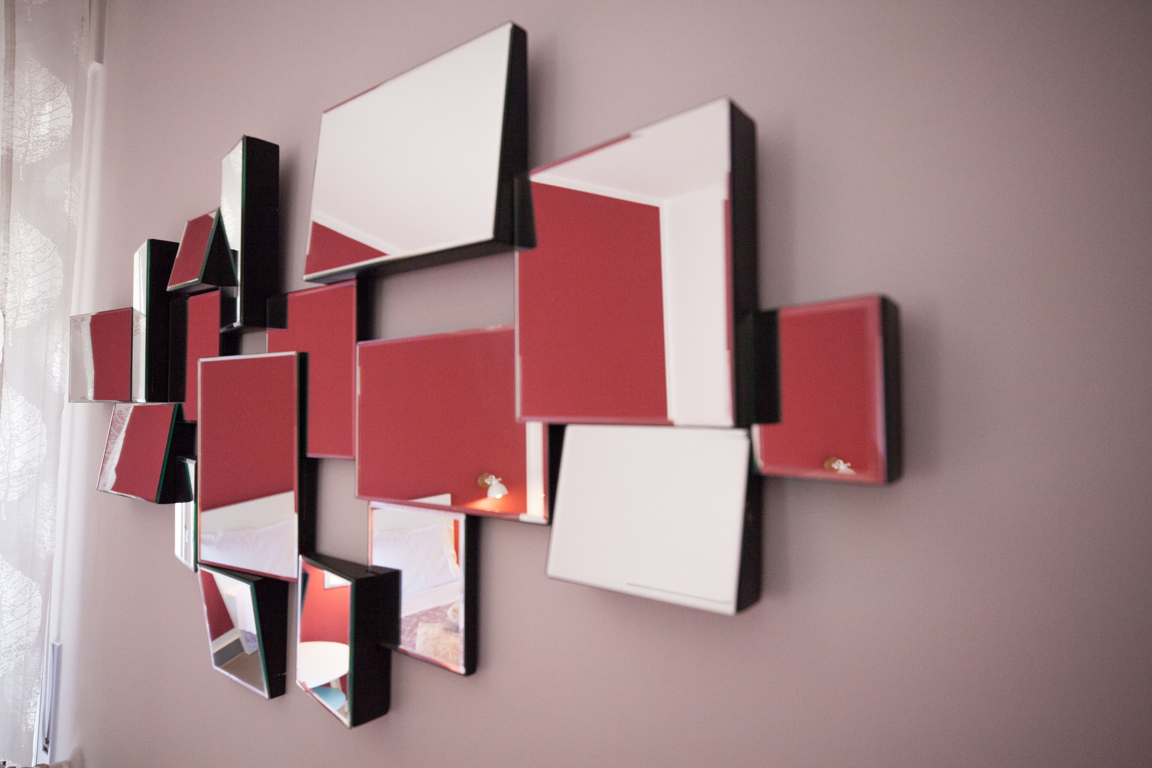 A wall with a geometric arrangement of mirrors and panels.