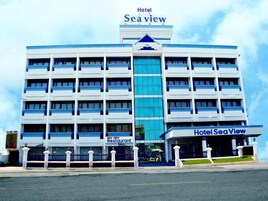 A multi-story hotel with a prominent 'Sea View' sign, a restaurant on the ground floor, and a modern architectural design.