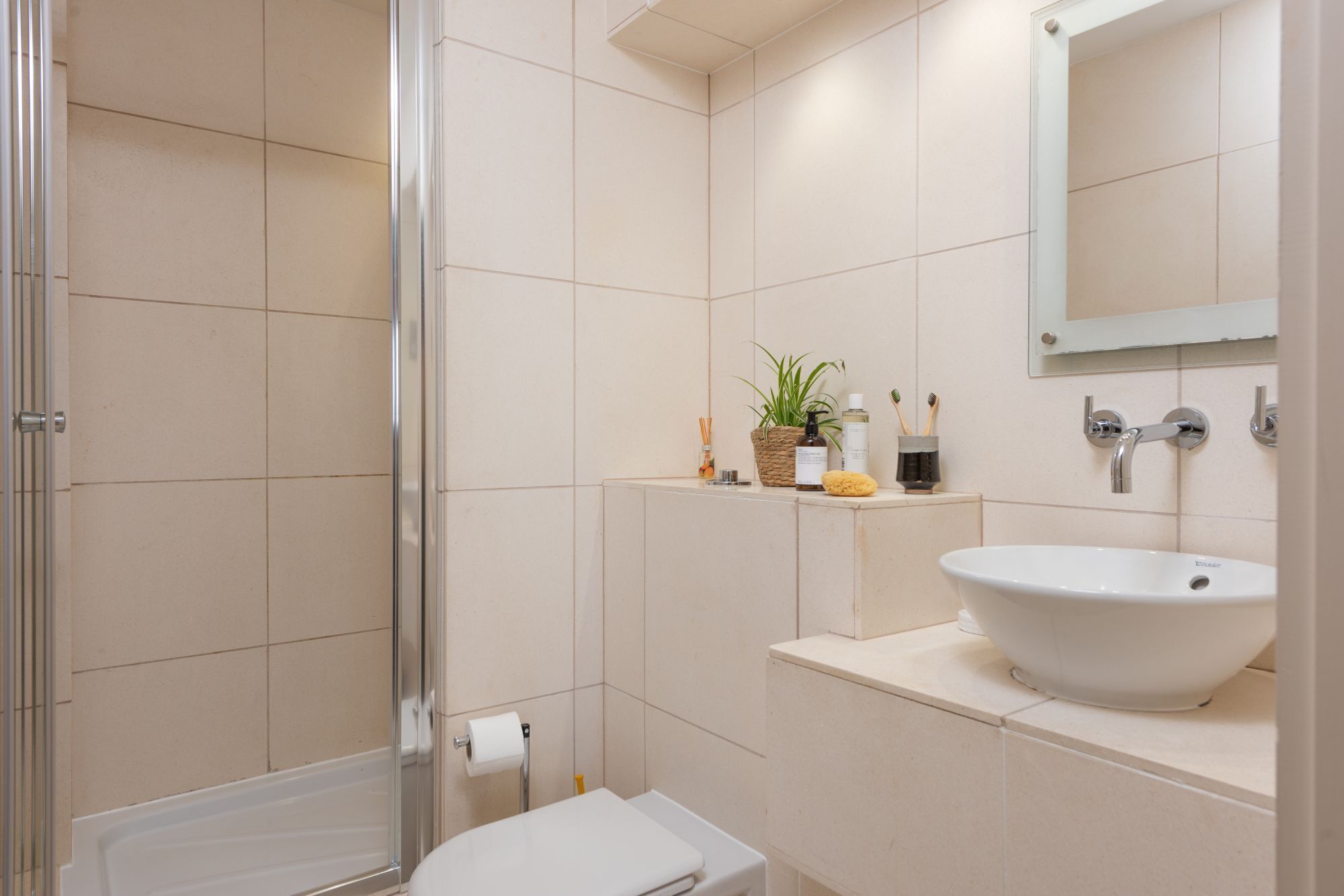 Une salle de bain moderne équipée d’une douche, de toilettes, d’un lavabo et d’un miroir.