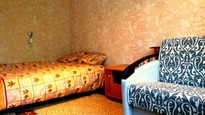 A bedroom with a bed, a chair, and a wardrobe. - Studio in the center near the Botanical Garden (Pechers'kyi district)