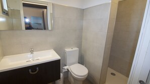 A bathroom with a white sink, toilet, and shower. - Hostal Sa Vinya Suites (Sant Joan de Labritja)