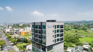 Un moderno edificio de hotel con varios pisos, ventanas amplias y techo plano.