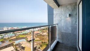 Un balcón con vistas al océano y edificios circundantes.