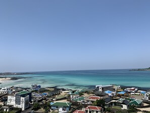 A coastal residential area with houses and a beach. - Lemain hotel (Jeju City)