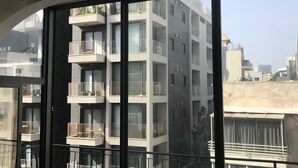 Eine moderne Wohnung mit großen Fenstern, Balkonen mit Geländern und Blick auf die Nachbargebäude.