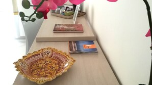 A wooden table with a decorative bowl, a magazine, and a potted plant.