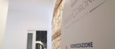 A wall with a sign for "ISANTI CORONATI" and "IGIENIZZAZIONE DELLE MANI".