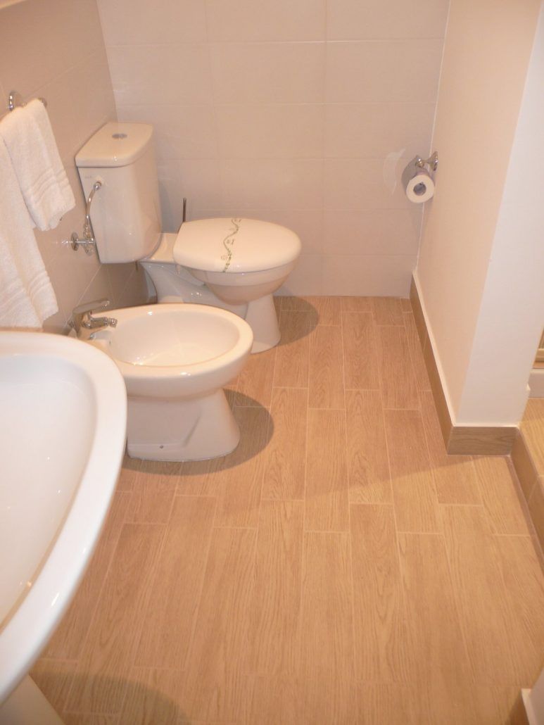 Un bagno con il water, bidet e lavandino.