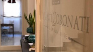 A hotel sign with the name "SANTI CORONATI" and "ORIGIA SUITE" visible.