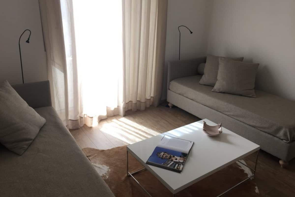 A modern living room with a sofa, a coffee table, and a lamp.