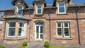 A traditional stone building with a central entrance, bay windows, and a small balcony. - Inverness (Inverness)