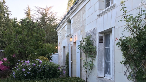 A white building with a garden area, including a hedge and flowering plants. - La Lézardière (Épeigné-les-Bois)