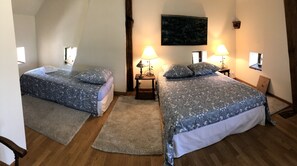 A bedroom with two beds, each with a patterned bedspread and matching pillows. There are two bedside lamps on wooden nightstands. A large abstract painting hangs on the wall above the beds. - La Lézardière (Épeigné-les-Bois)
