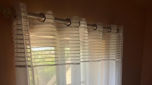 A room with a window covered by sheer white curtains. - La Lézardière (Épeigné-les-Bois)