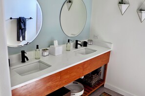 A bathroom with two sinks, a mirror, and a wooden vanity. - Luxury Getaway - Waterfront, 4 BD, hot tub, stargazing. (Canyon Lake)