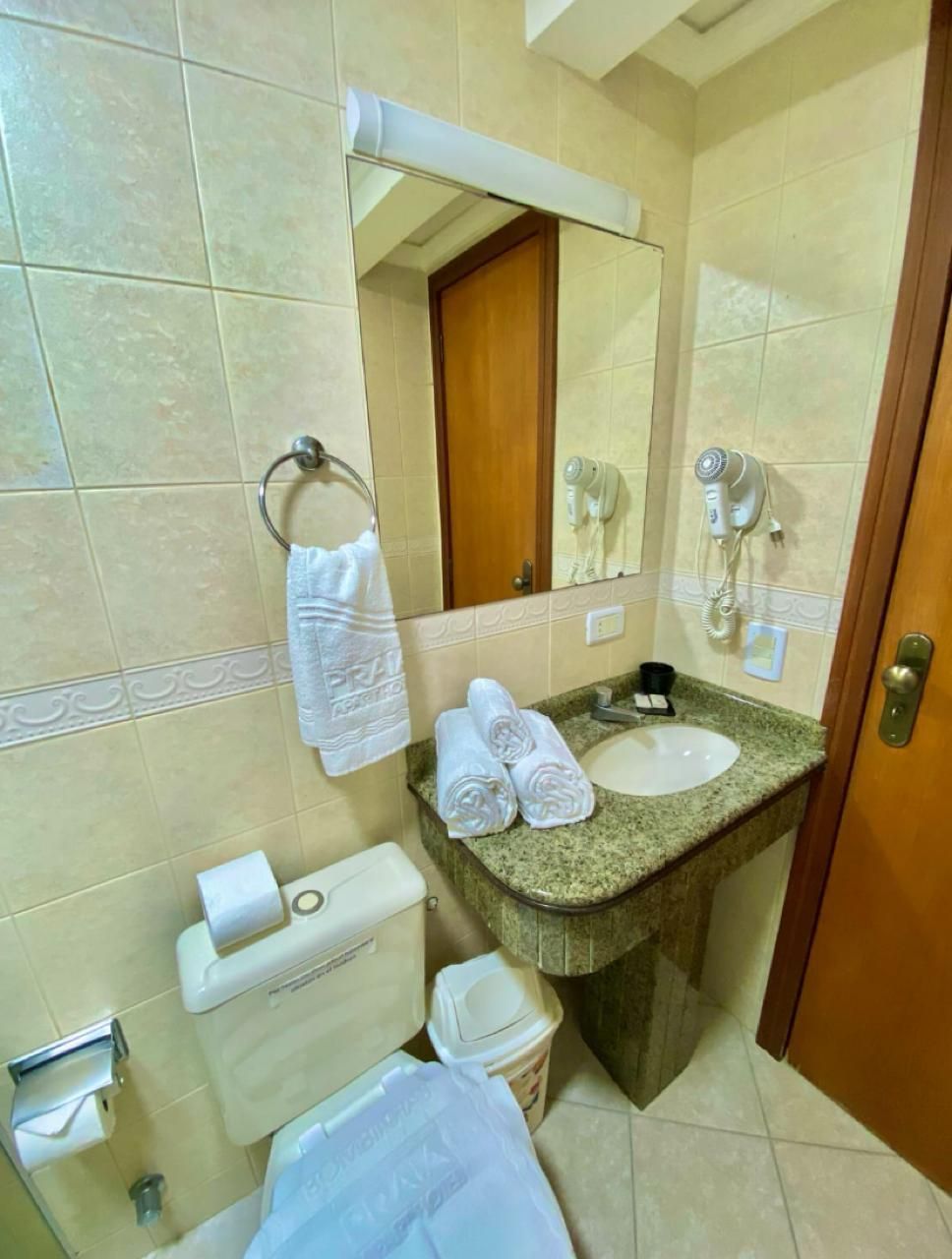 A bathroom with a sink, toilet, and a towel rack.