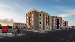 Um hotel de vários andares com design moderno, apresentando um pátio central e estacionamento.