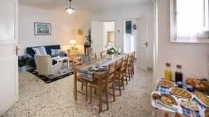 A dining area with a long wooden table set for a meal, surrounded by chairs. - Bella Vista b&b (Erice)