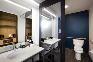 Un baño moderno con dos lavamanos, un espejo y un inodoro.