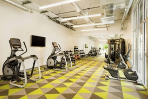A gym with treadmills, elliptical machines, and free weights.
