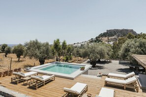 Relax by the pool surrounded by a deck with lounge chairs and a table.