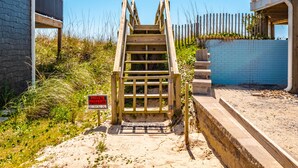 A wooden staircase leading to a gated entrance of a beachfront property. - Blue Haven | Ocean Views, Private Pool + Beach Access! (Surf City)
