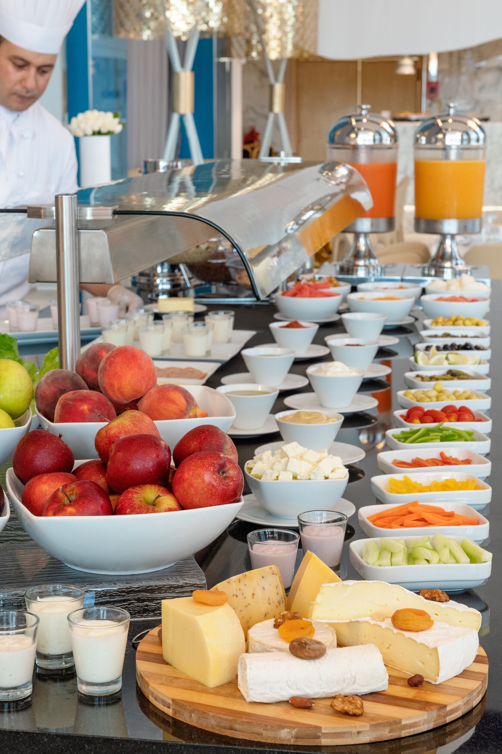 A buffet with various food items including fruits, cheeses, and vegetables.