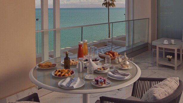 A balcony with a table set for breakfast, overlooking the sea. - Marchica Lagoon Resort (Beni Ansar)