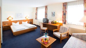 A hotel room with a bed, a desk, a chair, and a small table with fruit. - Trip Inn Frankfurt Airport Russelsheim (Ruesselsheim)