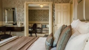 A hotel room with a bed, a desk, and a chair.
