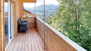 Una terraza de madera con vistas a un pueblo y montañas.