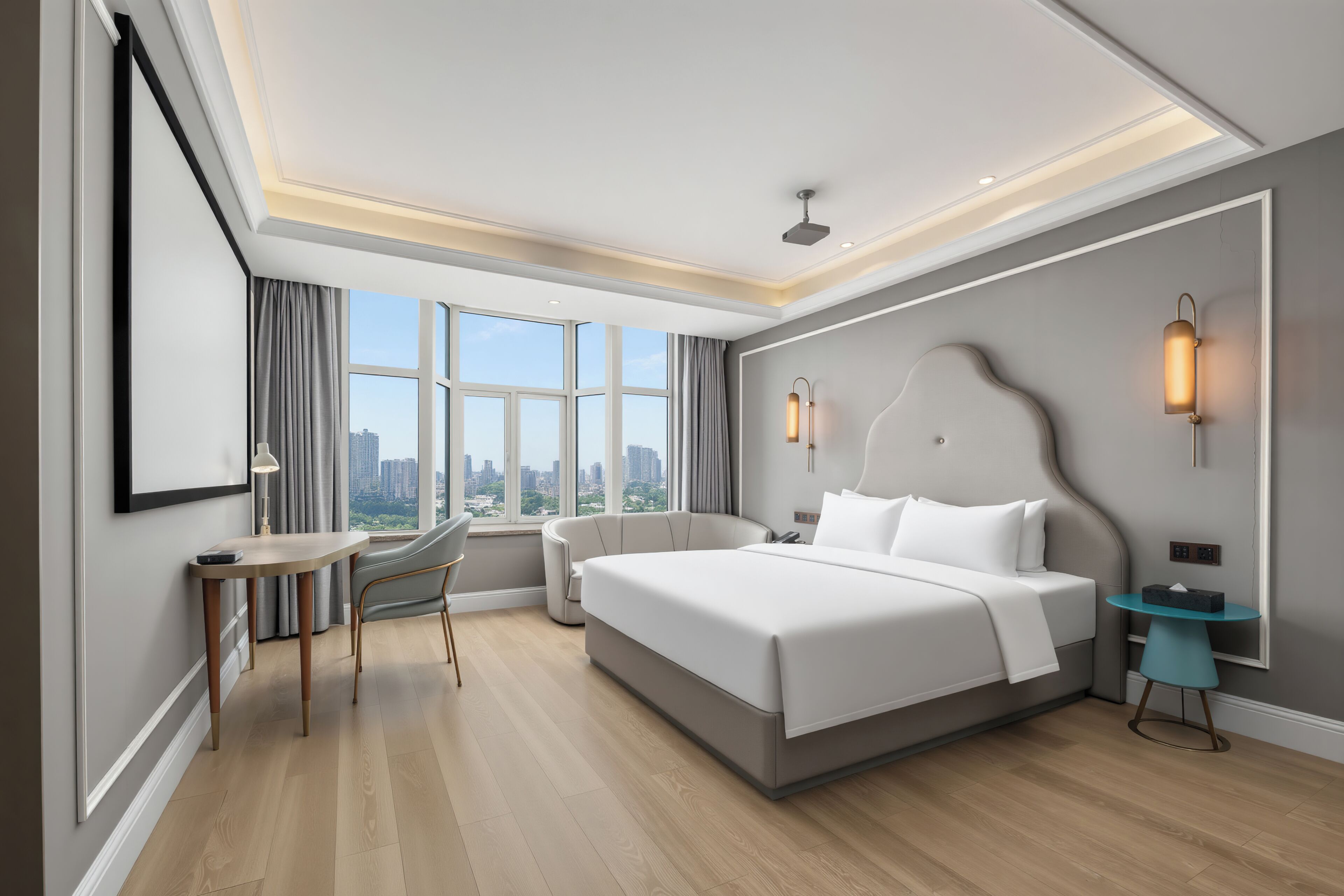Een moderne hotelkamer met een groot bed, een bureau, een stoel, een bijzettafeltje en uitzicht op de stad door grote ramen.