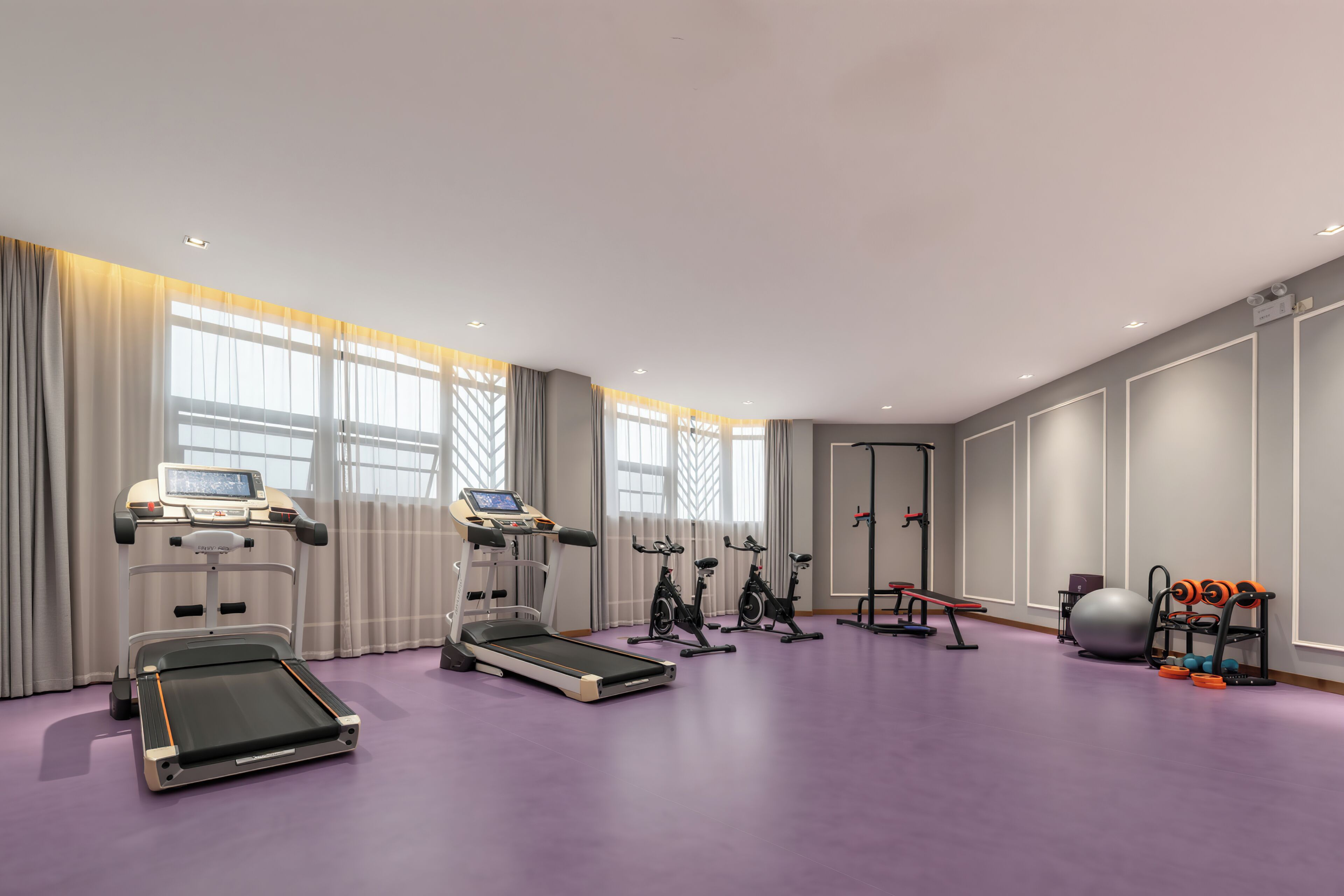 Una sala de fitness moderna amb equip de cardio, una bicicleta estatica i una màquina d'a rem.