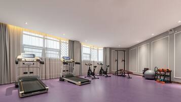 Una sala de fitness moderna amb equip de cardio, una bicicleta estatica i una màquina d'a rem.