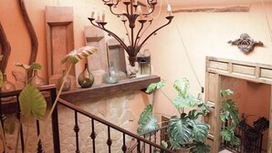A staircase with a wrought iron railing, surrounded by various potted plants and decorative items. - Casa Rural Herrera (Villacarrillo)