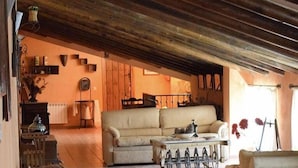 A cozy living room with a sofa, a coffee table, and a fireplace. - Casa Rural Herrera (Villacarrillo)