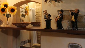 A room with a mirror reflecting sunflowers, a basket, and a shelf with figurines.