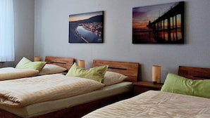 A hotel room with two single beds, a nightstand, and two wall-mounted paintings. - Apartmenthaus Abendsonne (Koblenz)