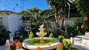 A garden with a central fountain, surrounded by decorative statues and plants. - Rancho Grande (Marbella)