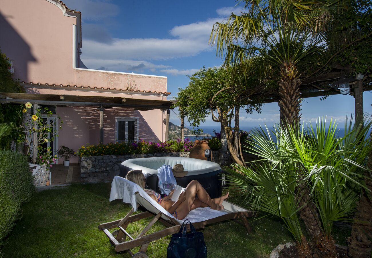 Un espacio al aire libre privado con piscina, sillones de descanso y vistas al mar.