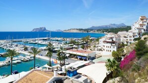 A coastal marina with boats, a clear blue sky, and buildings with white facades. - Miramar by Interhome (Moraira)