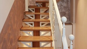 Eine Holztreppe mit weißen Geländern und einer Marmorwand.