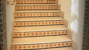 Un escalier orné de carreaux décoratifs menant à une pièce.