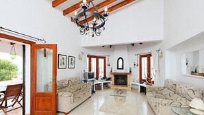 A spacious living room with a fireplace, two sofas, a television, and a chandelier. - Esperanza by Interhome (Pego)