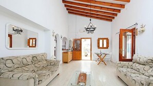 A spacious living room with two sofas, a glass coffee table, and a kitchen in the background. - Esperanza by Interhome (Pego)