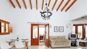 A spacious living area with a dining table, chairs, a sofa, and a TV. - Esperanza by Interhome (Pego)