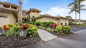 A residential area with houses, a paved driveway, and landscaped gardens with various plants. - 🏖️Family-Friendly | Pools, Beach Gear, Golf & Walk to A-Bay Adventures (Waikoloa)