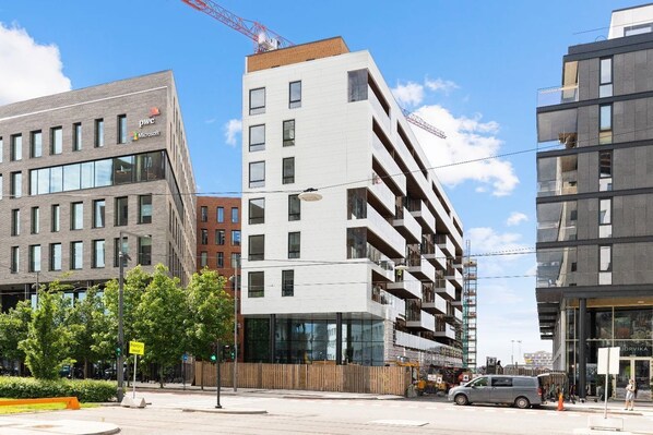 A multi-story building with a modern architectural design, featuring a mix of glass and concrete facades.