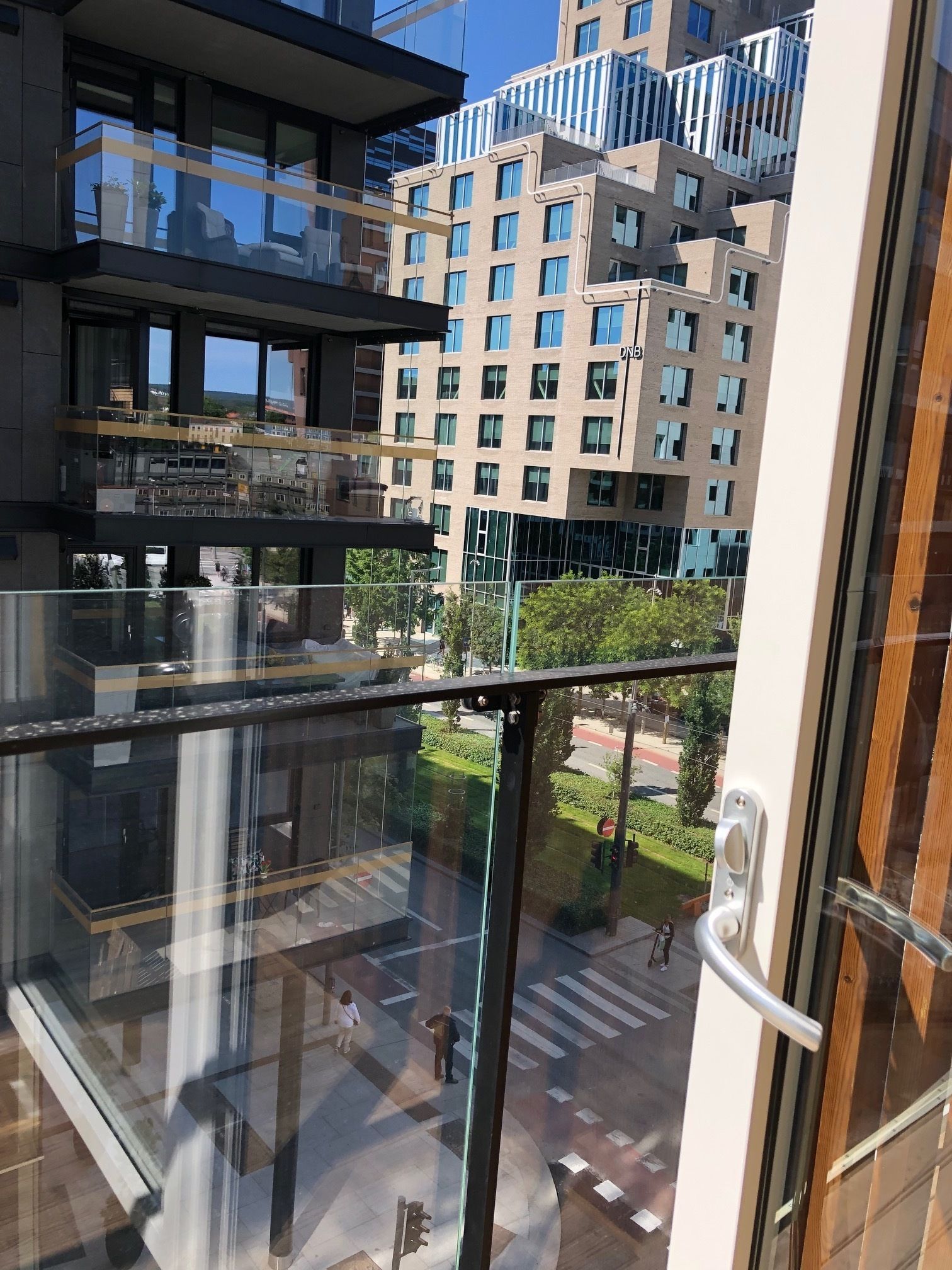 A modern building with multiple floors, large windows, and a glass balcony.